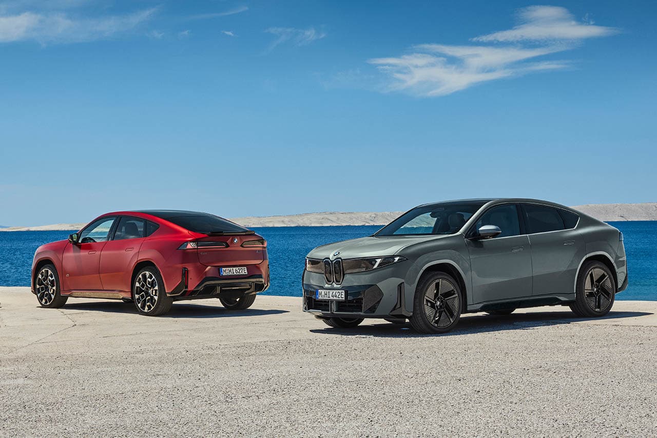 Piros és szürke BMW iX4 egymás mellett a tengerparton