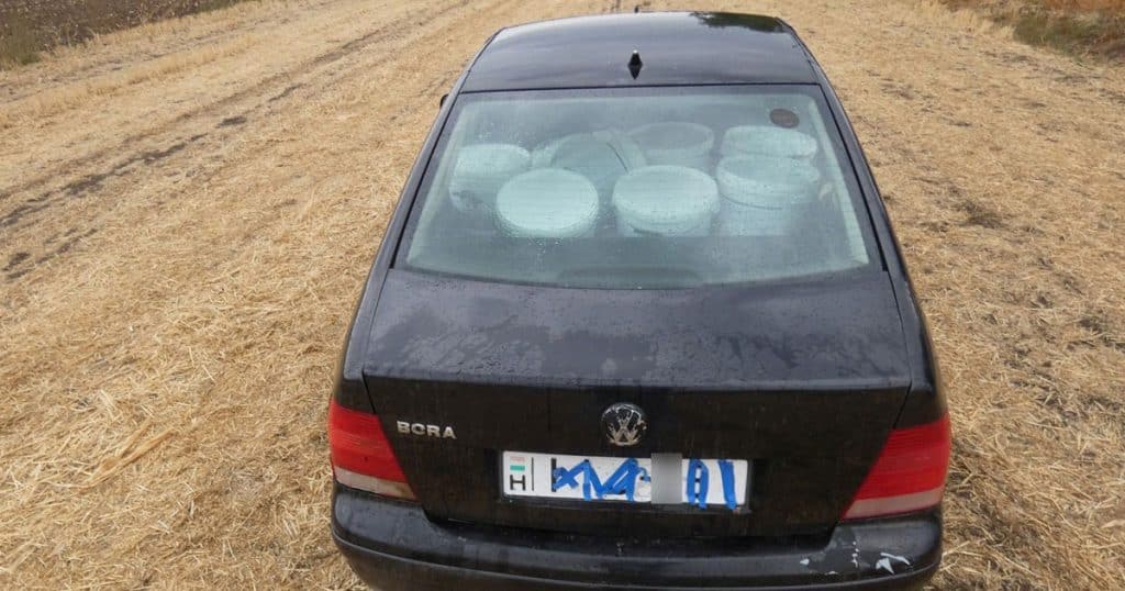 Fekete Volkswagen egy tarlón, a hátsó ülésen glettesvödrökkel, leragasztott rendszámmal
