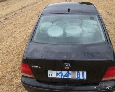 Fekete Volkswagen egy tarlón, a hátsó ülésen glettesvödrökkel, leragasztott rendszámmal