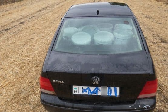 Fekete Volkswagen egy tarlón, a hátsó ülésen glettesvödrökkel, leragasztott rendszámmal