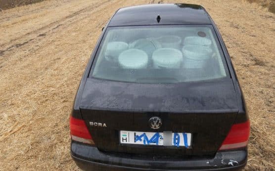 Fekete Volkswagen egy tarlón, a hátsó ülésen glettesvödrökkel, leragasztott rendszámmal